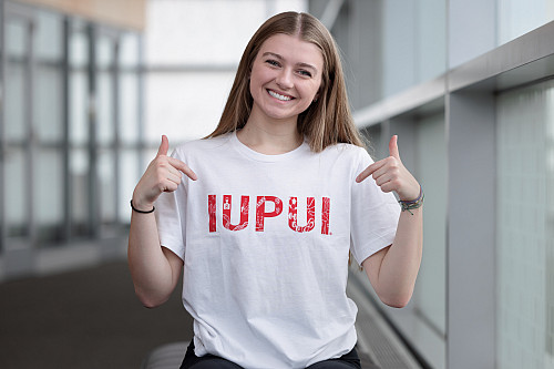 IUPUI student Cadee Thompson poses for a portrait along with the winning t-shirt she designed. (Photo by Liz Kaye/Indiana University)